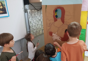 Dzieci malują portret Mona Lisy na kartonowym pudle